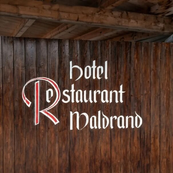 Le panneau officiel avec le logo de l'Hôtel Restaurant Waldrand sur la façade traditionnelle en bois.