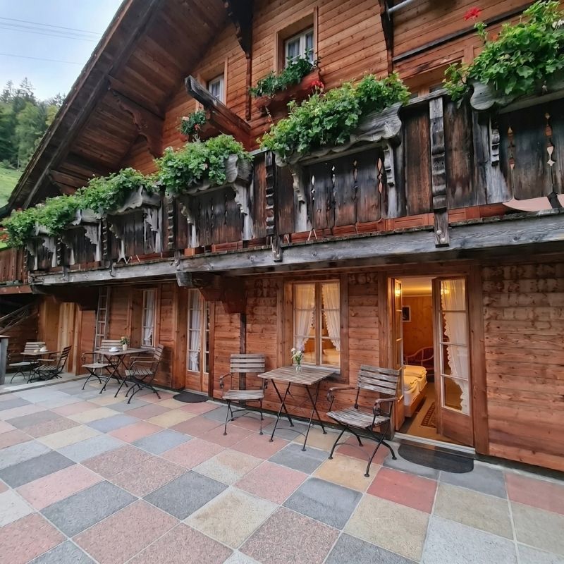 Traditionelle Holzterrasse des Hotels Waldrand mit gemütlichen Sitzgelegenheiten im Freien.