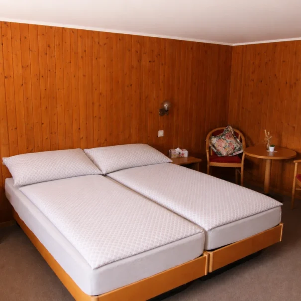 Rustikales Doppelzimmer im Chalet-Stil mit Holztäfelung im Hotel Waldrand Isenfluh.