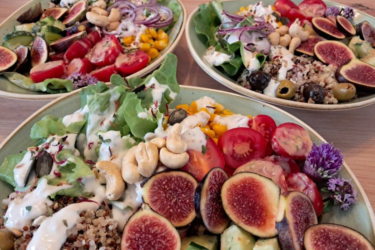 Salad bowl sain et coloré avec des figues fraîches, des tomates cerises, des noix de cajou et de la vinaigrette à l'Hôtel Restaurant Waldrand.